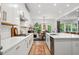 Bright kitchen featuring white cabinets, countertops, stainless appliances, and pendant lighting with a view to the breakfast area at 6045 Stargazer Way, Cumming, GA 30028