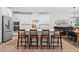 Modern kitchen with white cabinetry, stainless steel appliances, large island and four wood bar stools at 6045 Stargazer Way, Cumming, GA 30028