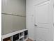 Mud room area with gray beadboard, storage cubbies, and a white door at 6045 Stargazer Way, Cumming, GA 30028