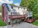 An elevated deck, sunroom, brick chimney and a peek at the garage highlight this home's backyard at 6841 Fairway Ridge Dr, Douglasville, GA 30134