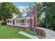 Charming brick house with a covered front porch, brick chimney, and landscaped surroundings at 6841 Fairway Ridge Dr, Douglasville, GA 30134