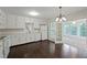 Bright kitchen with white cabinetry, stainless steel sink, and adjacent sunroom at 6841 Fairway Ridge Dr, Douglasville, GA 30134