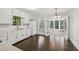 Bright kitchen with white cabinetry, stainless steel sink, and view to a sunroom at 6841 Fairway Ridge Dr, Douglasville, GA 30134