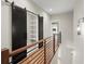 Hallway on upper floor features hardwood floors and sliding barn door to storage area at 2329 Mason Dr # D24, Atlanta, GA 30316