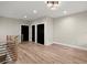 Open living room with wood-style floors, black interior doors, and a modern wood and metal railing at 2329 Mason Dr # D24, Atlanta, GA 30316