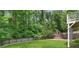 Large backyard with a well-maintained lawn, wooden fence, playhouse, and mature trees at 2602 Drew Valley Ne Rd, Brookhaven, GA 30319