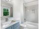 Bathroom with a gray vanity, white subway tile, and a tub with a shower head at 2602 Drew Valley Ne Rd, Brookhaven, GA 30319