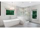 Spa-like bathroom with soaking tub, chandelier, frameless shower, and natural light at 2602 Drew Valley Ne Rd, Brookhaven, GA 30319