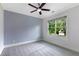 Bedroom with a ceiling fan and windows bringing in natural light and a blue accent wall at 2602 Drew Valley Ne Rd, Brookhaven, GA 30319