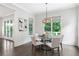 Bright dining room features a glass table, chandelier, and views of the beautiful landscape at 2602 Drew Valley Ne Rd, Brookhaven, GA 30319