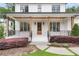 Inviting front porch with wood pillars, decorative shrubs, and a stained wood front door at 2602 Drew Valley Ne Rd, Brookhaven, GA 30319