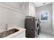 Laundry room with a modern washer and dryer set, a sink, and patterned floors at 2602 Drew Valley Ne Rd, Brookhaven, GA 30319