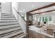 Living room adjacent to staircase features exposed wood beams and a cozy fireplace at 2602 Drew Valley Ne Rd, Brookhaven, GA 30319