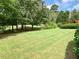 Green backyard featuring well-maintained grass and mature trees, perfect for outdoor activities at 9602 Coastal Pointe Dr, Villa Rica, GA 30180