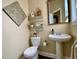 Charming powder room with a pedestal sink, decorative shelves, and a stylish mirror at 9602 Coastal Pointe Dr, Villa Rica, GA 30180