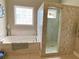 Soaking tub and large shower in the bathroom offers a spa-like experience, illuminated by a window at 9602 Coastal Pointe Dr, Villa Rica, GA 30180