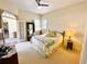 Bright bedroom featuring a ceiling fan, neutral walls, plush carpet, and French doors that lead to an outdoor area at 9602 Coastal Pointe Dr, Villa Rica, GA 30180