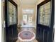 Welcoming foyer with decorative double doors, hardwood floors, a vibrant area rug, and transom window with natural light at 9602 Coastal Pointe Dr, Villa Rica, GA 30180