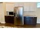 Modern kitchen with stainless steel refrigerator, dark countertops, and white cabinets offers a sleek and functional design at 9602 Coastal Pointe Dr, Villa Rica, GA 30180