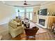 Living room with fireplace, large windows, and comfortable seating arrangement at 9602 Coastal Pointe Dr, Villa Rica, GA 30180