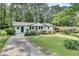 A lovely single-story home with a long, winding driveway, a green lawn, and mature trees behind the house at 1891 Sahara Se Dr, Atlanta, GA 30316