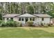 Charming single-story home with white brick, a green door, and a well-manicured lawn and flower bed at 1891 Sahara Se Dr, Atlanta, GA 30316