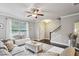 Cozy living room with large window, bench seat, ceiling fan, hardwood floors, and staircase at 2023 Yellow Finch Trl, Atlanta, GA 30316