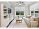Bright living room features built-ins, hardwood floors, a ceiling fan, and a large window at 2023 Yellow Finch Trl, Atlanta, GA 30316