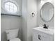 Powder room with a modern round mirror, a new vanity and a unique octagonal window at 3362 Palm Nw Cir, Kennesaw, GA 30144