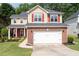 Charming two-story home with brick accents, red shutters, an American flag, a well-manicured lawn and an attached two-car garage at 3362 Palm Nw Cir, Kennesaw, GA 30144
