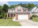 Charming two-story home with brick accents, red shutters, an American flag, a well-manicured lawn and an attached two-car garage at 3362 Palm Nw Cir, Kennesaw, GA 30144