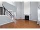 Open-concept living room with a fireplace, hardwood floors, and an elegant staircase at 3362 Palm Nw Cir, Kennesaw, GA 30144