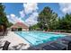 A pristine community pool with lounge chairs, umbrellas, and a covered seating area, surrounded by lush trees at 3362 Palm Nw Cir, Kennesaw, GA 30144