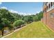 Lush backyard featuring mature trees, a well-manicured lawn, and a tranquil waterfront view at 55 Rocky Ne Cir, White, GA 30184