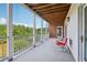 Outdoor balcony with brick siding features two red chairs with a view of the tree line at 55 Rocky Ne Cir, White, GA 30184