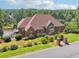 Lovely brick house featuring an attractive red roof, well-manicured lawn, and lakeside access at 55 Rocky Ne Cir, White, GA 30184
