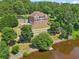 Beautiful home with multiple decks overlooking a serene waterfront, surrounded by mature trees at 55 Rocky Ne Cir, White, GA 30184