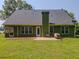 Back exterior with a screened porch, patio, and lush lawn with mature trees at 10 Stewart Hollow Ln, Covington, GA 30016
