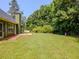 Spacious backyard with a patio, lush lawn, and mature trees, offering ample outdoor space at 10 Stewart Hollow Ln, Covington, GA 30016