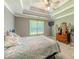 Main bedroom featuring a tray ceiling, ceiling fan, neutral decor, dresser, and window at 10 Stewart Hollow Ln, Covington, GA 30016