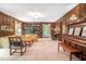 The living room features wood paneling, a piano, and a built-in bookshelf at 1310 Chilton Woods Rd, Rutledge, GA 30663