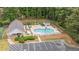 Overhead view of community pool with lounge chairs and a parking lot, surrounded by lush green trees at 2722 Brookhaven Ln, Buford, GA 30518