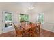 Dining area with wood table, chairs, and views of screened-in porch and backyard at 2722 Brookhaven Ln, Buford, GA 30518