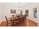 Formal dining room featuring a large table with ten chairs, hardwood floors, and elegant chandelier lighting at 2722 Brookhaven Ln, Buford, GA 30518