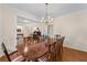 Classic dining room with dark wood table, striped chairs and open floor plan to living area at 2722 Brookhaven Ln, Buford, GA 30518
