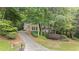 A charming home nestled among trees with a long driveway leading up to the house and an attached two car garage at 2722 Brookhaven Ln, Buford, GA 30518