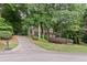 A charming home nestled among trees with a long driveway leading up to the house and an attached two car garage at 2722 Brookhaven Ln, Buford, GA 30518