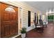 Inviting front porch with a stained wood floor, rocking chairs, and a decorative front door at 2722 Brookhaven Ln, Buford, GA 30518
