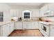Well-lit kitchen with white cabinets, granite countertops, and modern appliances at 2722 Brookhaven Ln, Buford, GA 30518