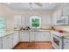 Well-lit kitchen with white cabinetry, granite counters, and modern appliances at 2722 Brookhaven Ln, Buford, GA 30518